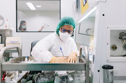 Female pharmacist writing prescription on push cart in hospital
